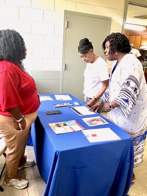 Community members reviewing campaign materials at an outreach table